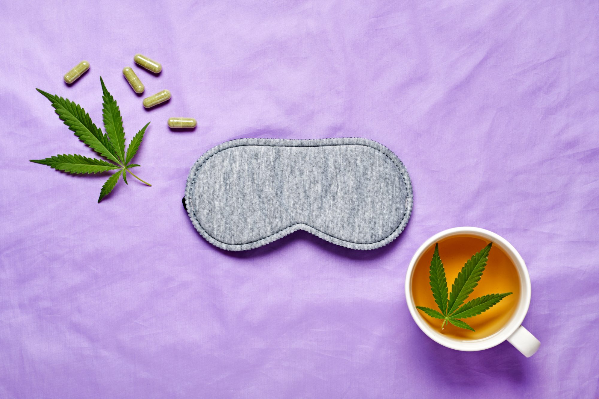 Cannabis and sleep concept with eye mask, hemp leaves, and calming setup